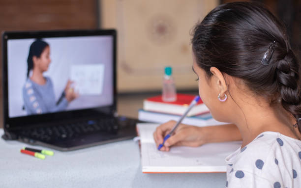 Female student preparing study notes from the internet (laptop)