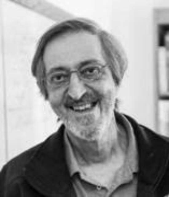 Mathematician Avi Wigderson in a cheerful pose in the library