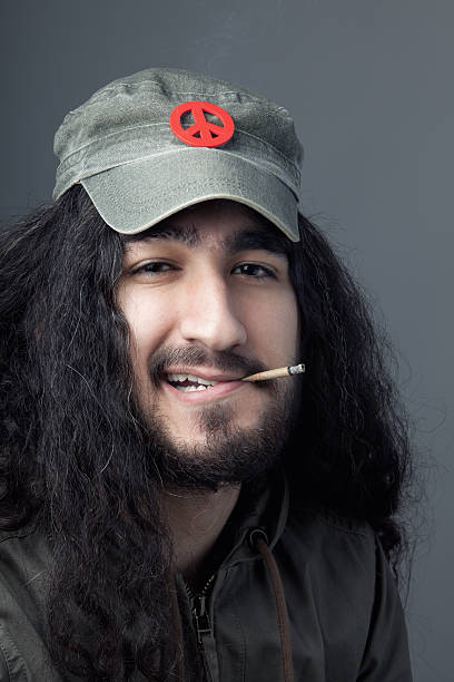 A distracted young man feeling relaxed while smoking a cigarette