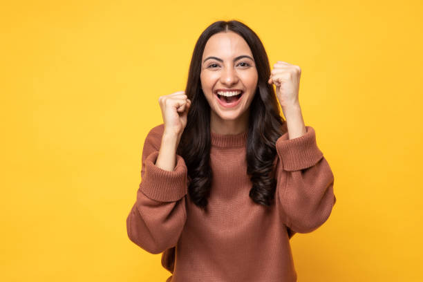 Female student expressing happiness with her hands raised on her success