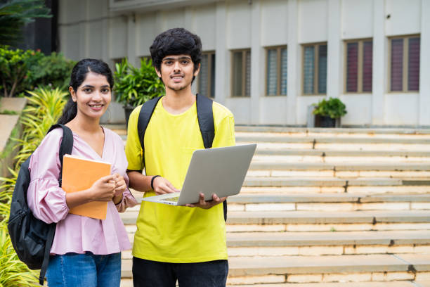 Female student and student expressing their happiness of success with laptop