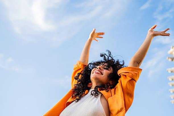 Female student overwhelmed by success with their hands up