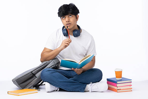 Pretending to be reading by a student who sits with a notebook in his hand and looks upwards
