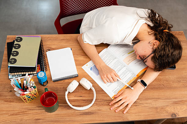 Girl student rests with her head on the table after studying math