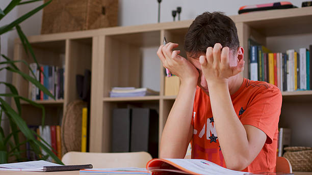 Student holding hands to rest eyes while studying mathematics