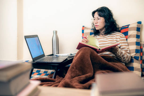 Female student concentrates and prepares math notes from laptop