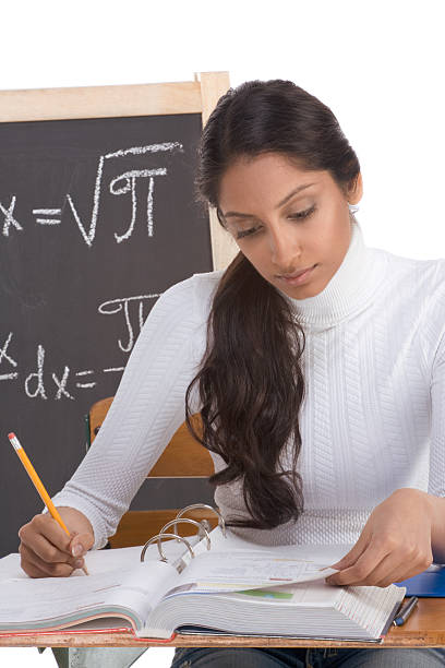 Female college student practicing math questions in a notebook