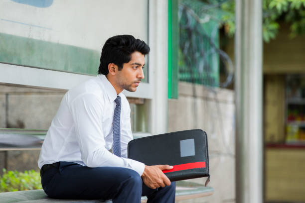 A student suffering from educated unemployment sits in a public place with his documents