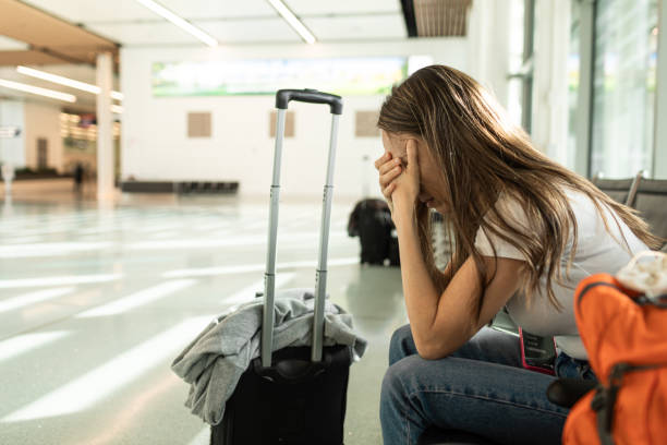 A female student,saddened by unemployment,sits holding her head in a public place