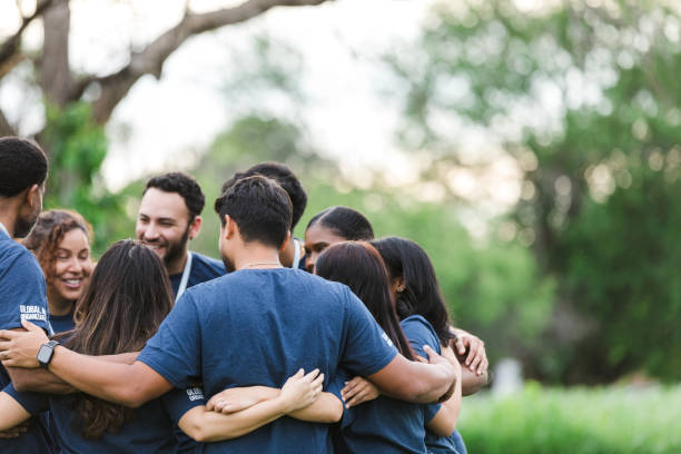 Students standing in a circle holding each other in a show of unity