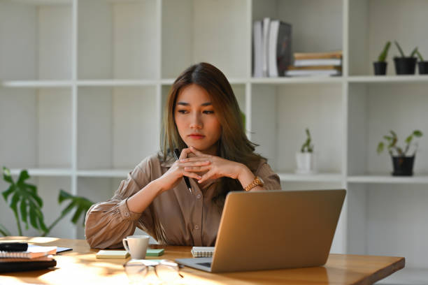 Female student sitting in front of a laptop feeling guilty