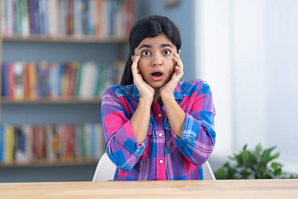 Female student puts her hand on her cheeks in the study room and feels guilty