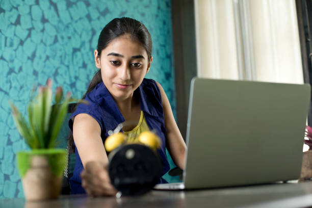 Female student writes notes from laptop to memorize