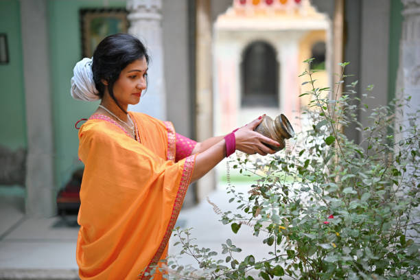 Religious woman offering water to Tulsi