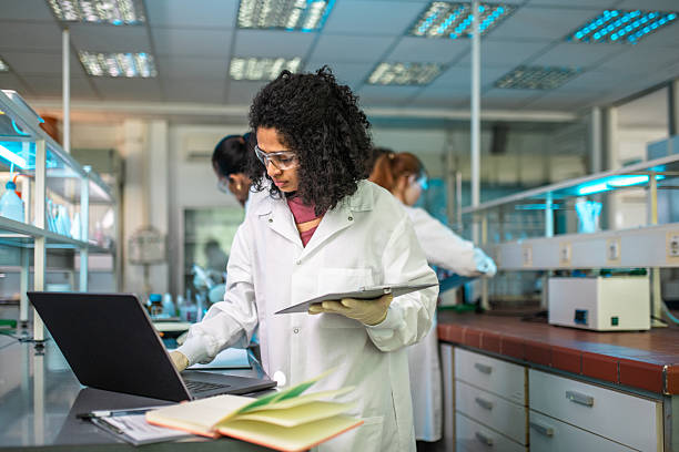 Chemistry professor searching with a laptop in the laboratory
