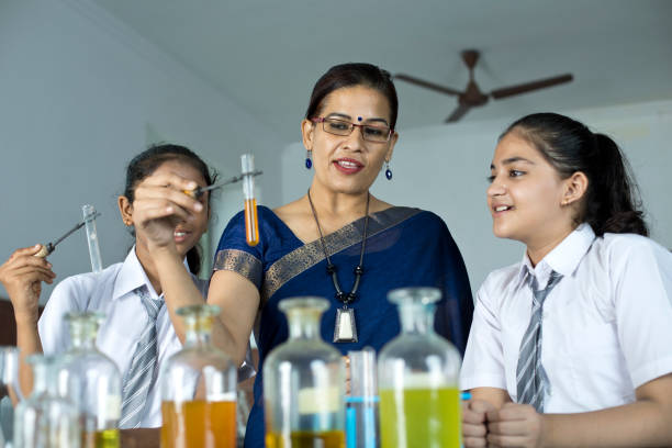 School lecturers conducting laboratory practicals of chemistry to students