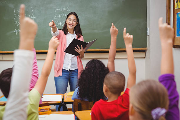 Female teacher asks math questions to students in class