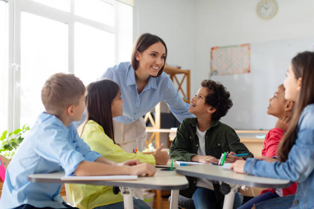Female teacher in class discusses with students to get feedback