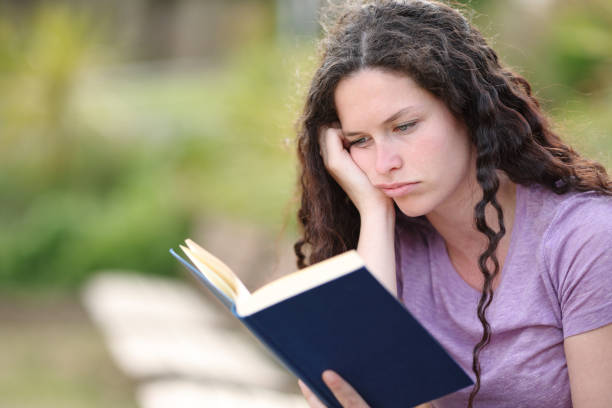 The girl student is studying the book under pressure