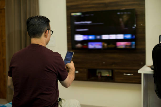 A person watching the news while watching TV in his home