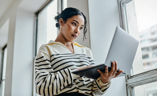Female student reading career-related news from laptop