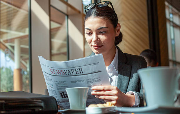 College female student reading career tips in newspaper
