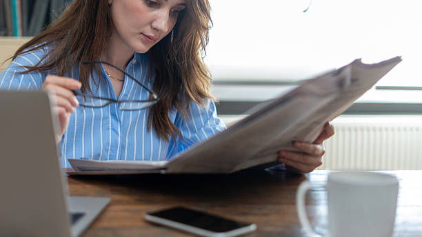 College female student reading the main news of the newspaper with attention