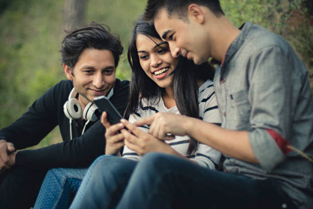 A student asking another student why he is surfing on mobile?