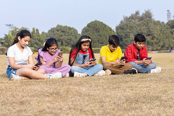 Students sitting in groups surfing the internet with their mobiles