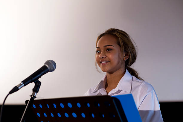 Little girl student doing public speaking with the microphone