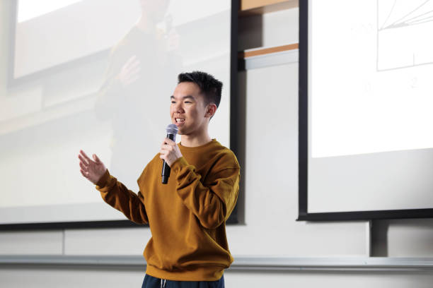 A student speaking to a microphone at the educational institution
