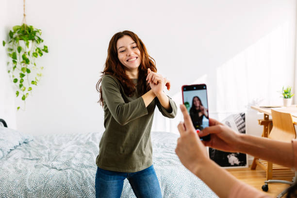 Student making reels of a female student with hands tied in front of her