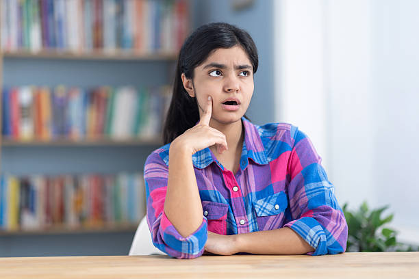 Female student contemplating after reading