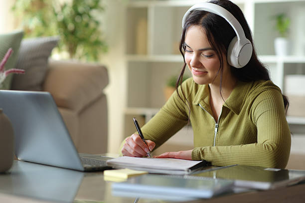 Girl student making notes for competitive exam with laptop