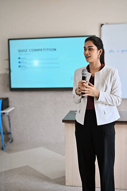Female teacher addressing the microphone in the classroom
