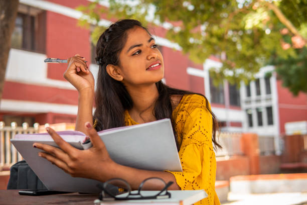Girl student thinking about something while studying herself