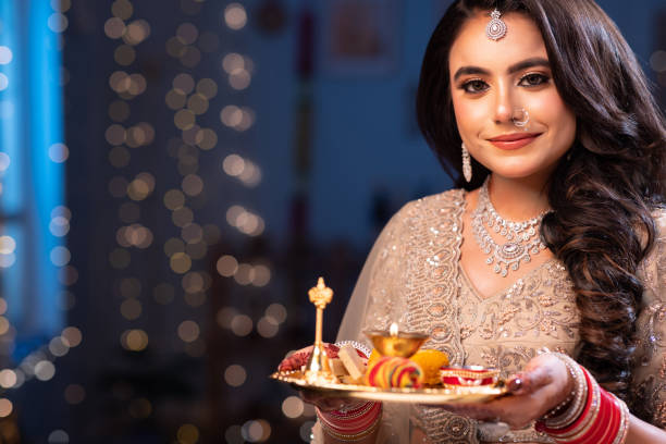 Hindu woman decorating incense lamps on a plate and preparing for aarti