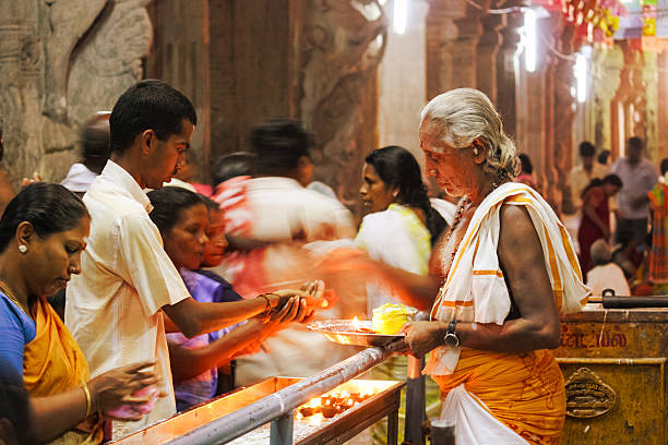 Devotees take prasad from the priest after performing aarti in the temple