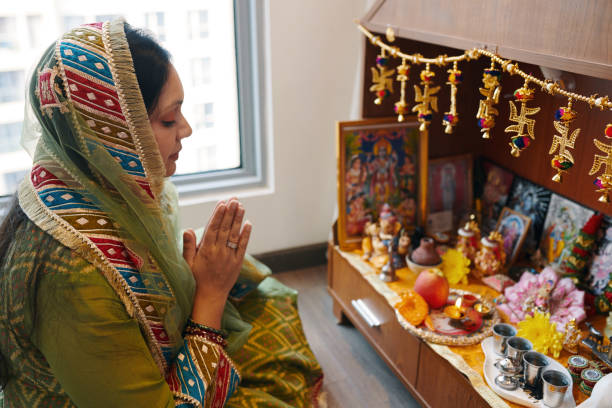 Hindu woman performing aarti in her house