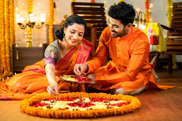 Hindu couple decorating the courtyard with flowers on the Hindu festival