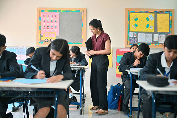The teacher will take the exam under the strict supervision of the students