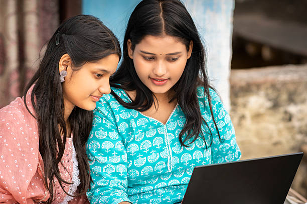 Mom is teaching her daughter how to operate a laptop