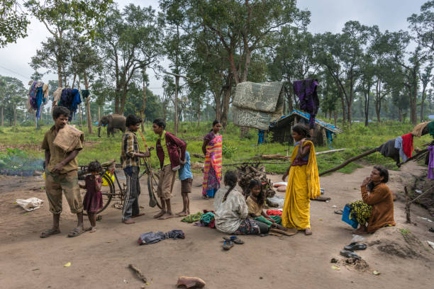 Adivasi children and women scattered here and there on the kutcha road