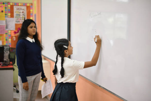 Girl Student solving math questions on the blackboard