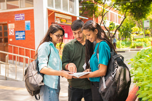 Students reading a book outside the examination hall