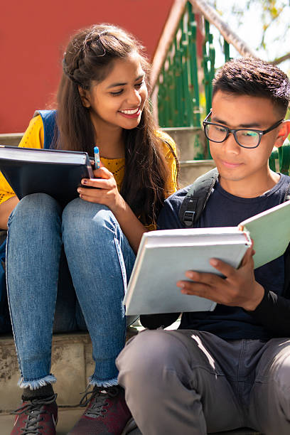 Female student and student sitting on the stairs preparing for the half-yearly examination
