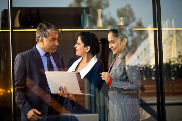 Female Employees Learning Techniques from Businessmen with Laptops