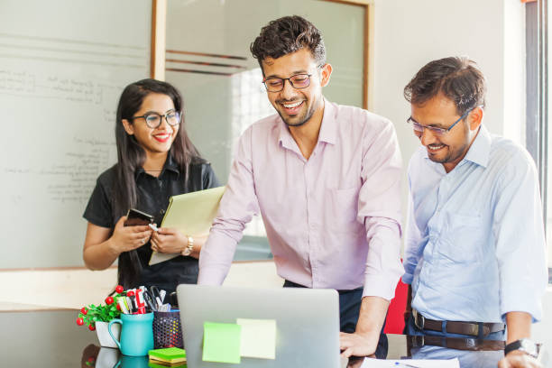 Retailers and woman employees looking at the technology of business from laptops
